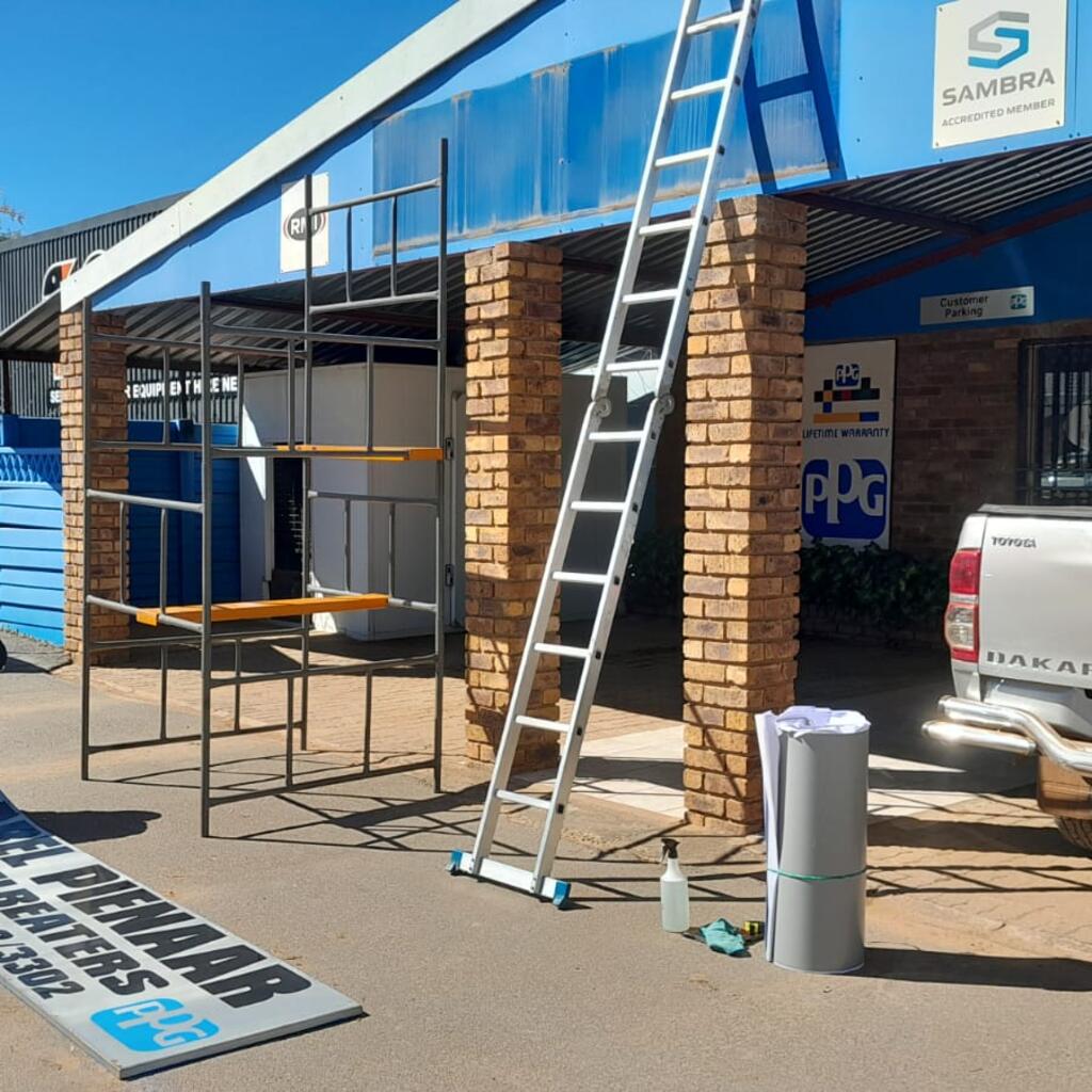 TSS technician preparing signage panel for refurbishment on site in Pretoria